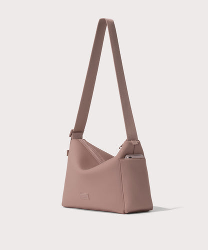 Shoulder bag in a pink seen from the angle view showing phone pocket.