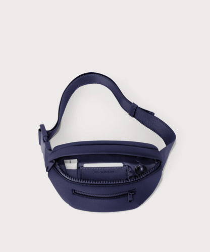 Dagne Dover Ace Fanny Pack in dark blue unzipped, exposing the interior pockets
