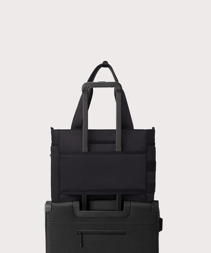Dagne Dover large Wade Diaper Tote in black with the neoprene luggage sleeve attached to a suitcase handle.