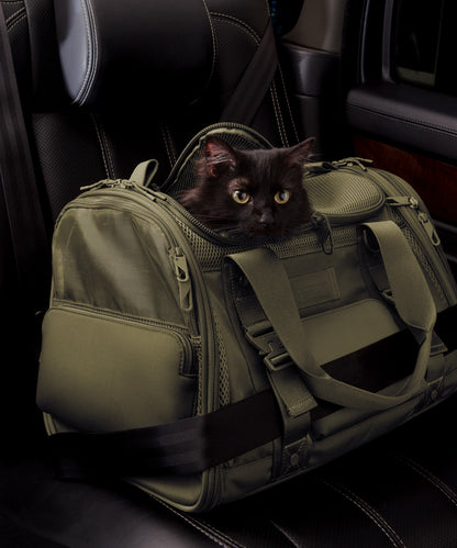 Dagne Dover Large Kyoto Pet Carrier in a deep olive green displaying the two side release buckle clips to secure pet carrier to seat belt; a cat is inside the carrier. Caption: Ouija is a 7.8-lb American Longhair