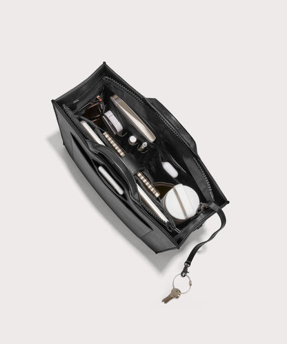 hover - Dagne Dover medium vegan Daily Tote in black from above, revealing the interior zipper, interior slip pockets, and padded laptop sleeve.